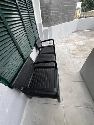 a black bench sitting on the side of a building at Serenity Apartment in Funchal