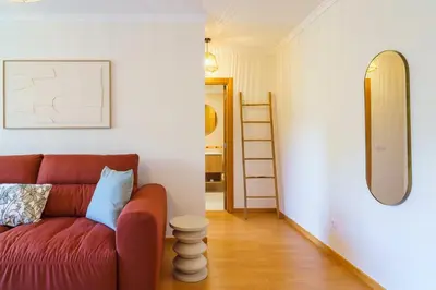 a living room with a red couch and a mirror at GuestReady - A sweet escape in Caniço in Santa Cruz