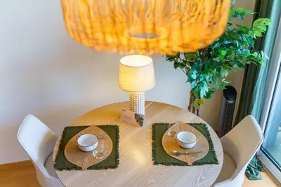 a wooden table with two plates and a lamp on it at GuestReady - A sweet escape in Caniço in Santa Cruz