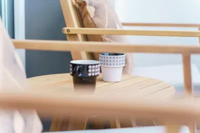 two coffee cups sitting on a wooden chair at GuestReady - A sweet escape in Caniço in Santa Cruz