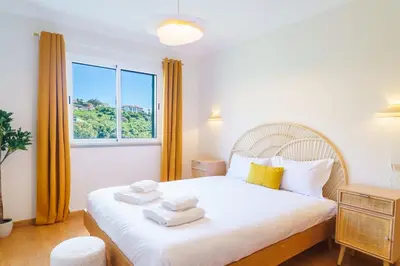 a bedroom with a large bed with towels on it at GuestReady - A sweet escape in Caniço in Santa Cruz