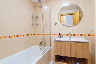 a bathroom with a tub and a sink and a mirror at GuestReady - A sweet escape in Caniço in Santa Cruz