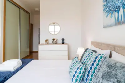 a bedroom with a white bed with blue pillows at GuestReady - Perfect family home in Caniço in Santa Cruz