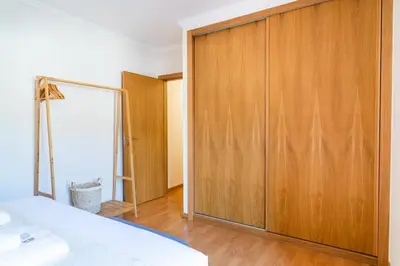 a bedroom with a wooden closet and a bed at GuestReady - The perfect hideout in Caniço in Caniço