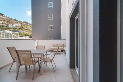 a balcony with a table and chairs on a building at GuestReady - The perfect hideout in Caniço in Caniço
