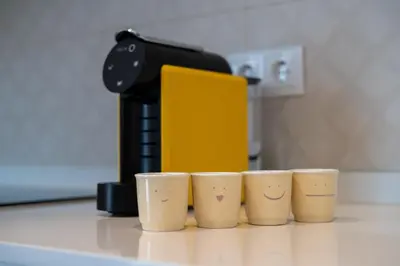four coffee cups sitting on a counter next to a coffee maker at Golden Tide in Machico