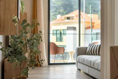 a living room with a couch and a large window at Golden Tide in Machico