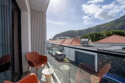 a balcony with a view of a car parked on the street at Golden Tide in Machico