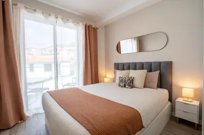 a bedroom with a bed and a large window at Golden Tide in Machico