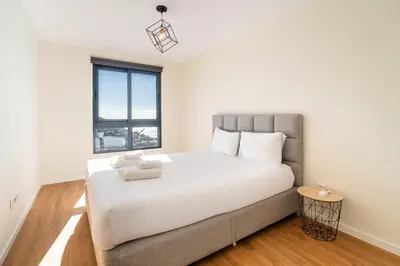 a bedroom with a large white bed and a window at GuestReady - Seaview Escape in Câmara de Lobos