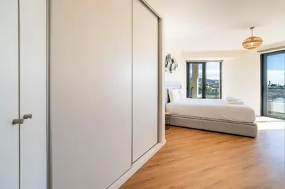 a bedroom with a bed and a sliding glass door at GuestReady - Seaview Escape in Câmara de Lobos