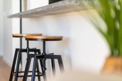 a row of bar stools sitting next to a wall at GuestReady - Seaview Escape in Câmara de Lobos