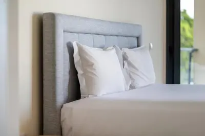 a bedroom with a bed with white pillows at GuestReady - Seaview Escape in Câmara de Lobos