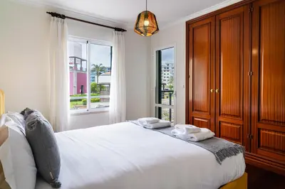 a bedroom with a large white bed and a window at GuestReady - Lovely experience in Funchal in Funchal