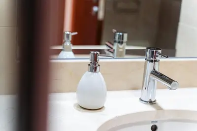 a white soap dispenser sitting on a bathroom sink at GuestReady - Peaceful haven in Funchal in Funchal
