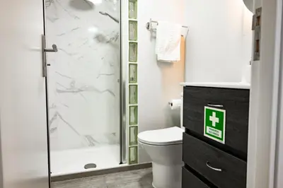 a bathroom with a toilet and a glass shower at LaurissilvaLodge in Senhora do Rosário