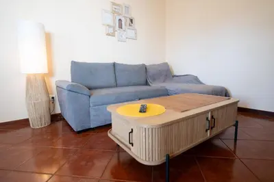 a living room with a blue couch and a coffee table at Ferienhaus Treibholz in Funchal