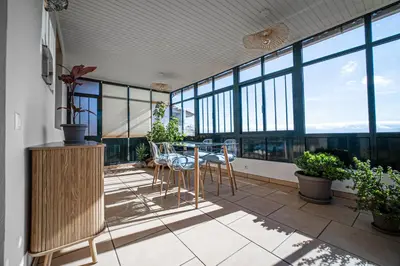a balcony with a table and chairs and windows at Ferienhaus Treibholz in Funchal