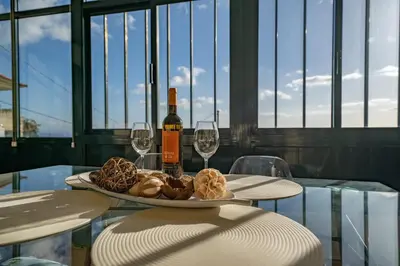 a table with a plate of food and wine glasses at Ferienhaus Treibholz in Funchal