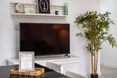 a living room with a tv and a table with a sign at Casa Susan in Ribeira Brava