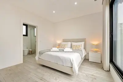 a white bedroom with a large bed and a window at Casa Susan in Ribeira Brava