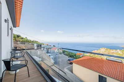 a balcony with chairs and a view of the ocean at Casa Isabel in Ribeira Brava