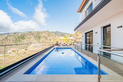 a swimming pool with a view of a house at Casa Isabel in Ribeira Brava