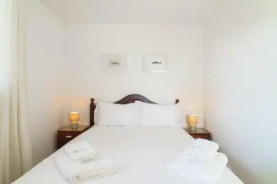 a bedroom with a white bed with two towels on it at GuestReady - Hillside Escape I in Câmara de Lobos