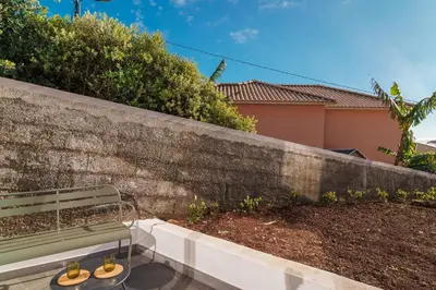 a bench sitting next to a stone wall at GuestReady - Hillside Escape I in Câmara de Lobos