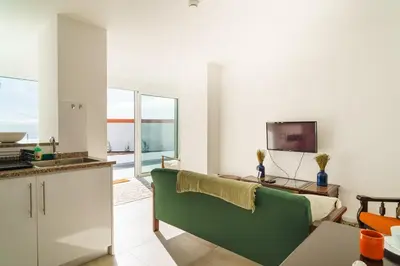 a living room with a green couch and a television at GuestReady - Hillside Escape I in Câmara de Lobos