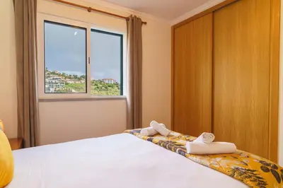 a bedroom with a bed with towels on it at GuestReady - Madeiran mountain view with pool in Santa Cruz