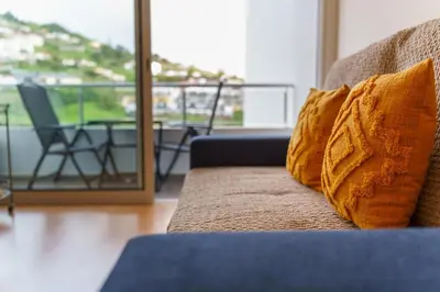 a couch with two pillows on it in a living room at GuestReady - Madeiran mountain view with pool in Santa Cruz