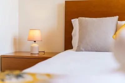 a bedroom with a bed and a lamp on a night stand at GuestReady - Madeiran mountain view with pool in Santa Cruz