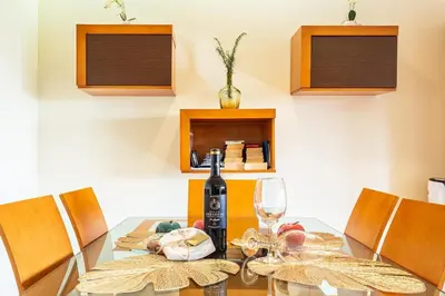 a dining room with a glass table with a bottle of wine at Bianka & Jose Apartment Funchal Madeira in Funchal