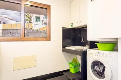a kitchen with a washing machine and a window at Bianka & Jose Apartment Funchal Madeira in Funchal