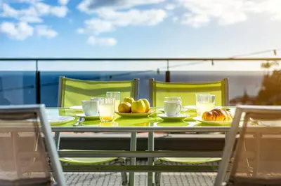 a table with food and drinks on a balcony at Bianka & Jose Apartment Funchal Madeira in Funchal
