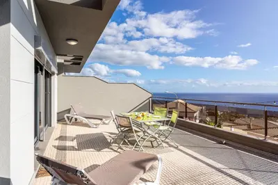 a balcony with a table and chairs and the ocean at Bianka & Jose Apartment Funchal Madeira in Funchal