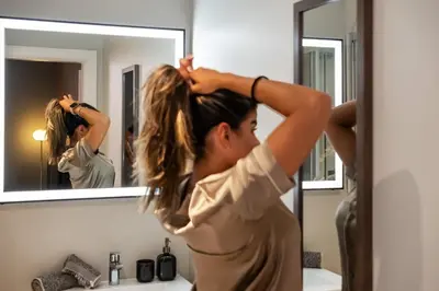 a woman brushing her hair in front of a mirror at Carmo in Funchal