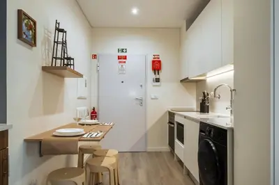 a kitchen with a sink and a table and chairs at Carmo in Funchal