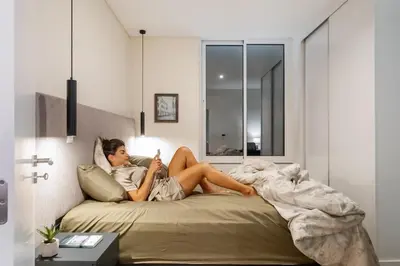 a woman sitting on a bed reading a book at Carmo in Funchal