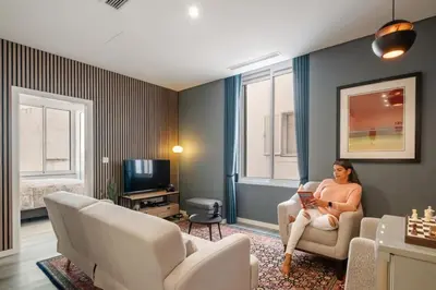 a woman sitting in a chair in a living room at Carmo in Funchal