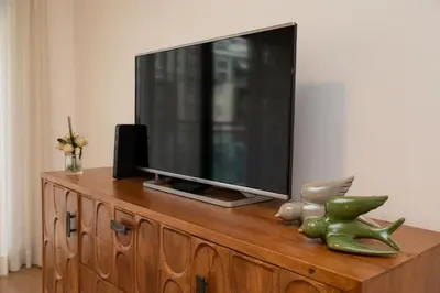 a tv sitting on top of a wooden dresser at October 5th Collection by Rent-a-key in Funchal