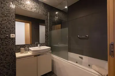 a bathroom with a sink and a tub and a mirror at October 5th Collection by Rent-a-key in Funchal