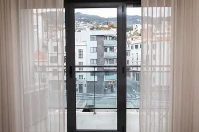an open window with a view of a city at October 5th Collection by Rent-a-key in Funchal