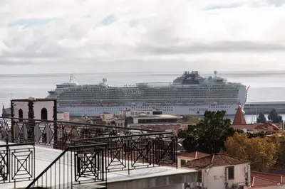 a cruise ship in the ocean with a city at October 5th Collection by Rent-a-key in Funchal