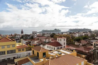 a view of a city with a cruise ship in the distance at October 5th Collection by Rent-a-key in Funchal
