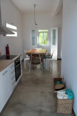 a kitchen with a table and a dining room at Aqua Sea House in Madalena do Mar