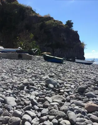 a rocky beach with three boats on it at Aqua Sea House in Madalena do Mar