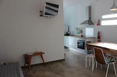 a kitchen with a table and a dining room at Aqua Sea House in Madalena do Mar