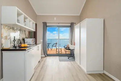 a balcony with two chairs and a table at Madeira Sunrise Villa in Gaula